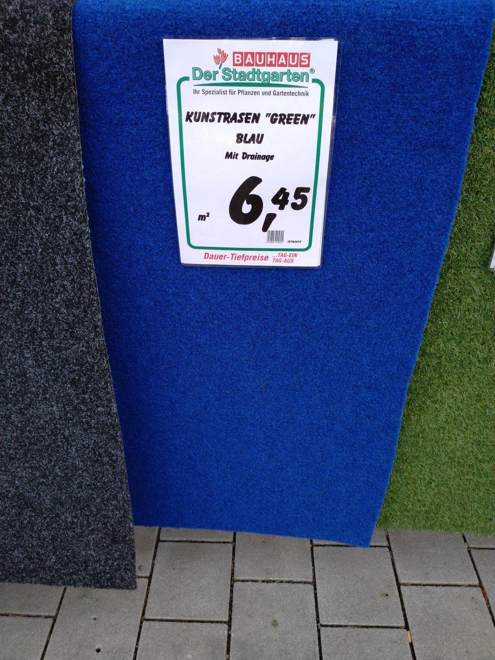 Blaues Kunstrasenstück in einem Baumarkt mit einem Preisschild. Auf diesem steht: 