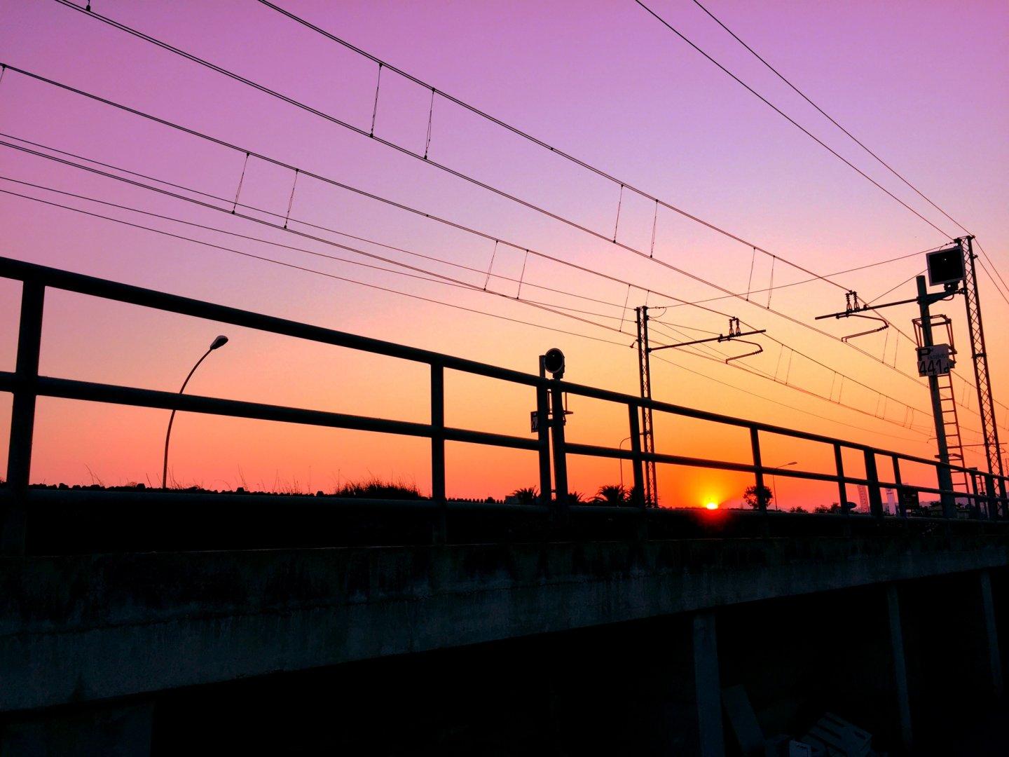 Sunset with train tracks in foreground.