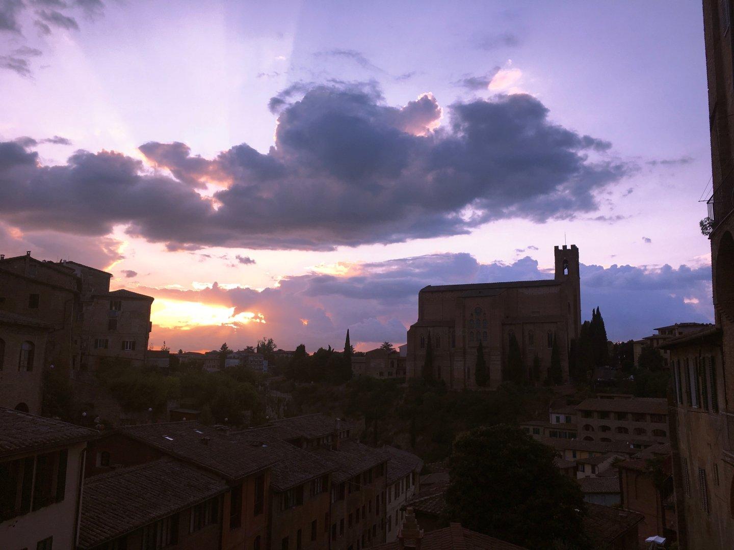 Cloudy Sunset in Siena, Italy. You can see sun rays clouds.